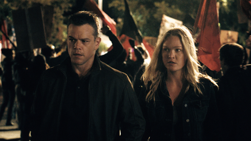 Entinen CIA-psykologi ja atk-velho Nicky Parsons ja Jason Bourne keskellä Ateenan mellakoita. Kuva: Universal Pictures. 