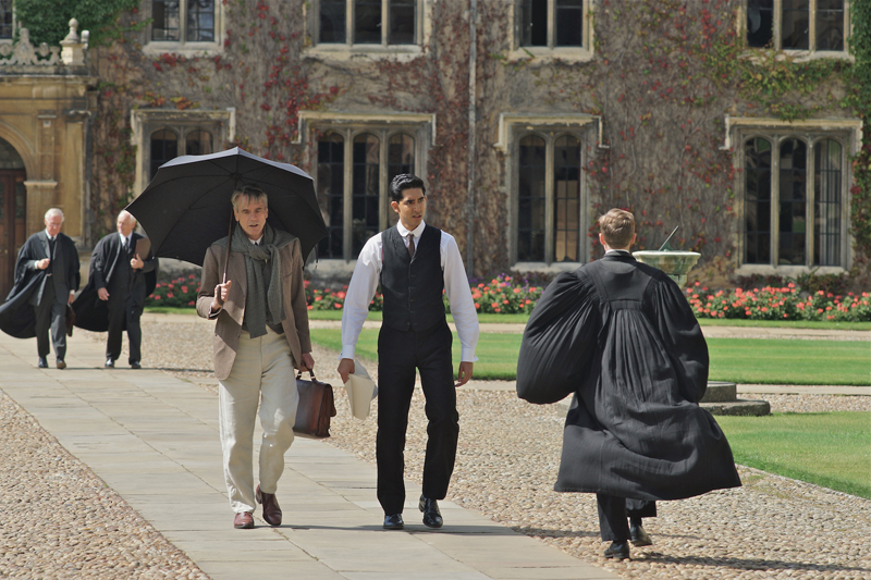G. H. Hardy (Jeremy Irons) ja Ramanujan kävelevät kivetyllä jalkakäytävällä, koska Ramanujan ei vielä ole fellow. Vain fellow sai oikaista kampuksen nurmialueen poikki. Kuva: Richard Blanshard.