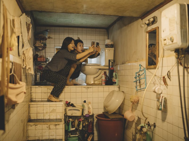 Kimin perheen lapset, tytär Ki-jeong ja poika Ki-woo kuvaushommissa pienessä kellariasunnossaan. Kuva: Future Film.